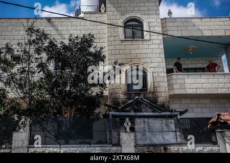 Qalqilya, Palästina. August 2024. Palästinenser sahen vom Balkon aus auf ihr zerstörtes und zerstörtes Haus, nachdem es von jüdischen Siedlern im Dorf JIT in der Nähe von Qalqilya im nördlichen besetzten Westjordanland angegriffen wurde. Jüdische Siedler griffen das palästinensische Dorf JIT an und verwüsteten den Ort, brannten Häuser und Autos in Brand und zerstörten öffentliches Eigentum, töteten einen Palästinenser und verletzten Dutzende. Quelle: SOPA Images Limited/Alamy Live News Stockfoto