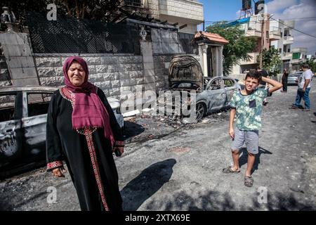 Qalqilya, Palästina. August 2024. Palästinenser wurden in der Nähe ihres beschädigten Hauses gesehen, nachdem es von jüdischen Siedlern im Dorf JIT in der Nähe von Qalqilya im nördlichen besetzten Westjordanland angegriffen wurde. Jüdische Siedler griffen das palästinensische Dorf JIT an und verwüsteten den Ort, brannten Häuser und Autos in Brand und zerstörten öffentliches Eigentum, töteten einen Palästinenser und verletzten Dutzende. Quelle: SOPA Images Limited/Alamy Live News Stockfoto