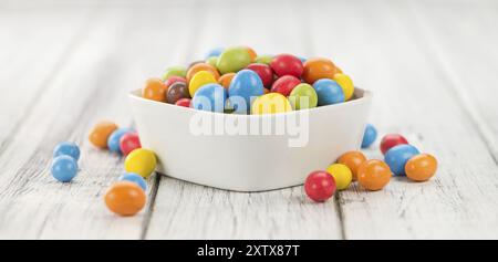 Cocolate beschichtet Erdnüsse auf rustikalen Holzmöbeln Hintergrund (Nahaufnahme) Stockfoto