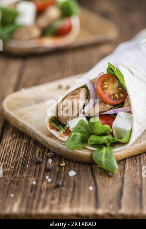 Chicken Wrap (Nahaufnahme, selektiver Fokus) auf Vintage-Holzhintergrund Stockfoto