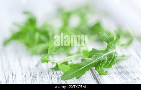 Frischer Arugula auf einem alten Holztisch als detaillierte Nahaufnahme Stockfoto