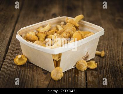 Pfifferlinge als detailreiche Nahaufnahme auf einem Vintage Holztisch, selektiver Fokus Stockfoto