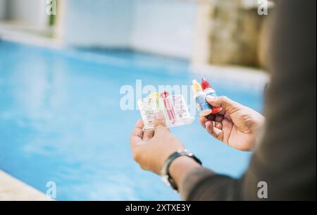 Person, die den pH-Wert des Schwimmbades überprüft. Handmessgerät zur Messung von Chlor und ph-wert in Schwimmbädern Stockfoto