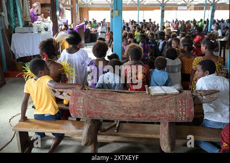 PAPUA NEUGUINEA, Madang, Dorf Riwo, Messe in katholischer Kirche , traditionelle Musikinstrumente wie die Garamut-Spalttrommel werden in der Messe verwendet / PAPUA NEUGUINEA, Madang, Dorf Riwo, katholische Kirche, Messe am Sonntag, Schlitztrommel Garamut Stockfoto