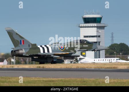 Flughafen London Southend, Essex, Großbritannien. August 2024. Die Royal Air Force hat zwei Eurofighter Typhoon-Kampfflugzeuge zum zivilen Flughafen geschickt, von wo aus sie für die viertägige Eastbourne Airshow eingesetzt werden. Einer der Jets (im Bild) ist speziell in einem RAF D-Day-Jubiläumsschema mit „Invasionsstreifen“ gemalt. Der Jet ist von seinem Display zurückgekehrt und bewegt sich nach der Landung am Flugverkehrskontrollturm Stockfoto