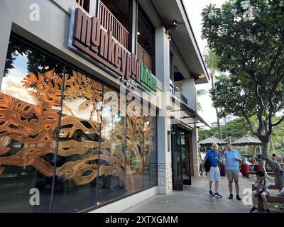 USA. Juli 2024. Äußere des Restaurants Monkeypod Kitchen mit dekorativer Fensterkunst in einer von Bäumen gesäumten Straße, Ali'inui Drive, Kapolei, Honolulu County, Hawaii, Juli 2024. (Foto: Smith Collection/Gado/SIPA USA) Credit: SIPA USA/Alamy Live News Stockfoto