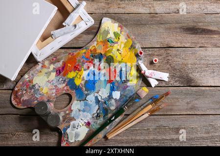 Künstlerpalette, Pinsel, Farben und leere Leinwände auf Holztisch, flache Lagen Stockfoto