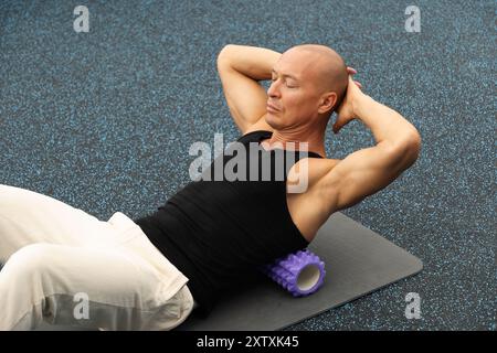 Auslösepunkt für Rückenmassage mit Schaumstoffrolle. Myofasziale Freisetzung. Stockfoto