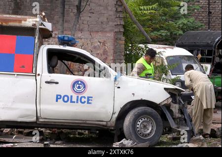 Ansicht des Standorts nach der Explosion, während Sicherheitsbeamte am Freitag, den 16. August 2024, zur Inspektion an der Warsak-Straße in Peshawar absperrten. Mindestens fünf Personen, darunter zwei Polizeikräfte, wurden bei einer Explosion an der Warsak-Straße im Gebiet PIR Bala verletzt. Laut Polizei war das Ziel der Explosion ein Polizeifahrzeug. Arshad Khan, Polizeichef der Warsak Road Superintendent of Police (SP), sagte, dass das Polizeifahrzeug infolge der „ferngesteuerten“ Explosion beschädigt worden sei. Stockfoto