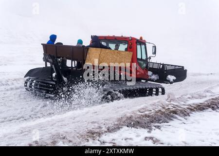 Elbrus, Russland - 01. August 2024: Transport von Touristen über einen schmelzenden Gletscher mit einer Schneekatze in einer Wolke an den Hängen des Mount Elbrus Stockfoto