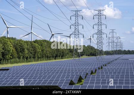 Hochspannungs-Stromleitung, der darunter liegende Raum wird für einen über 5 km langen Solarpark genutzt, dahinter ein Windpark, im Hafengebiet von Vlissingen- Stockfoto