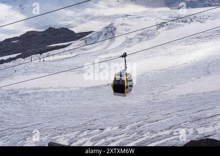 Elbrus, Russland - 31. Juli 2024: Gondelbahn auf dem Hang des Elbrus über der Gletscheroberfläche Stockfoto