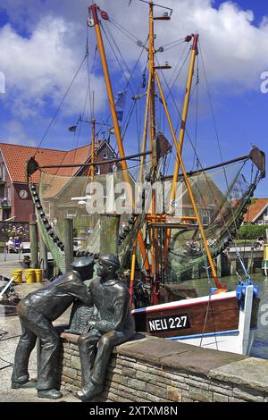 Der Hafen von Neuharlingersiel, Norddeutschland, Ostfriesland, Fischerdenkmal vor Fischerbooten, Neuharlingersiel, Niedersachsen, Bundesrepublik Deutschland Stockfoto