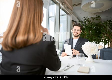 Ein Paar, das sich in einem modernen Restaurant verabredet und sich ansieht Stockfoto