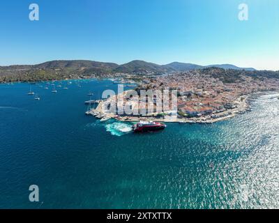 Griechenland, Drohnenansicht der Insel Poros im Saronischen Golf, Peloponnes, Gebäude am Meer und Boote im Meer, blauer Himmel Stockfoto