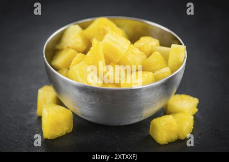 Teil der geschnittenen Ananas als detaillierte Nahaufnahme auf einer Schieferplatte, selektiver Fokus Stockfoto