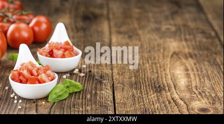 Tomaten (gewürfelt) als hoch detaillierte Nahaufnahme erschossen auf einem Vintage Holztisch (Tiefenschärfe) Stockfoto