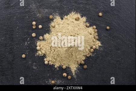 Teil White Pepper als detaillierte Nahaufnahme auf einer Schieferplatte, selektiver Fokus Stockfoto