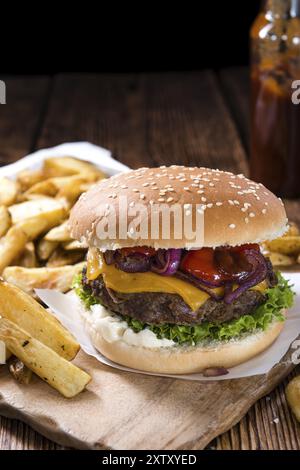 Big Burger mit hausgemachten Pommes Frites auf rustikalen hölzernen Hintergrund Stockfoto