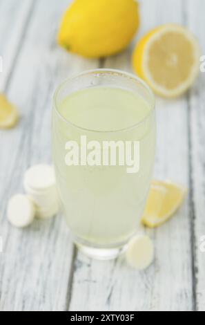 Vitamin-C-Tabletten als detailreiche Nahaufnahme auf einem Vintage-Holztisch, selektiver Fokus Stockfoto