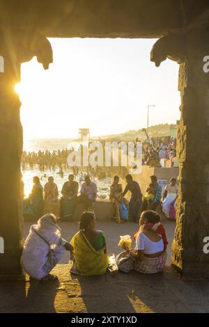 Kanyakumari, Indien, 22. Februar 2015: Indianer, Touristen sitzen und entspannen am Strand in der Nähe des 16-beinigen Mandapfelpavillons am Abend. Stockfoto