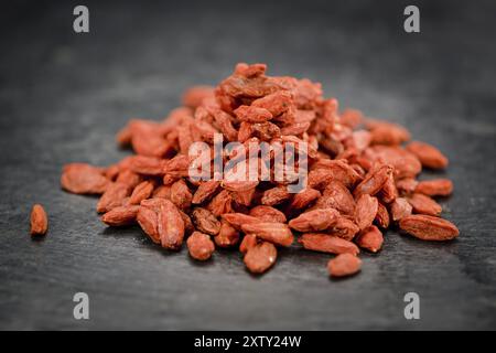 Teil getrockneter Goji-Beeren auf einer rustikalen Schieferplatte (selektiver Fokus, Nahaufnahme) Stockfoto