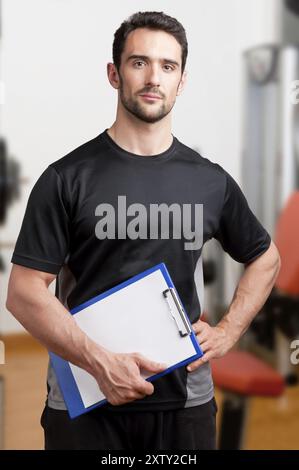 Personal Trainer, mit einem Pad in der Hand, in ein Fitness-Studio Stockfoto