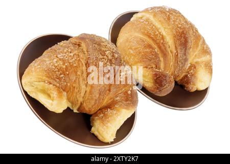 Zwei Croissants serviert auf dunklen braunen keramisches Geschirr, isoliert auf weiss Stockfoto