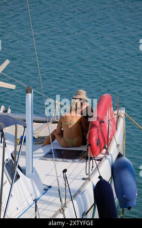 Italien, Sizilien, Mittelmeer, Marina di Ragusa (Provinz Ragusa); 16. August 2024, Frauen, die sich auf einem Katamaran-Segelboot im Hafen von EDITORI entspannen Stockfoto