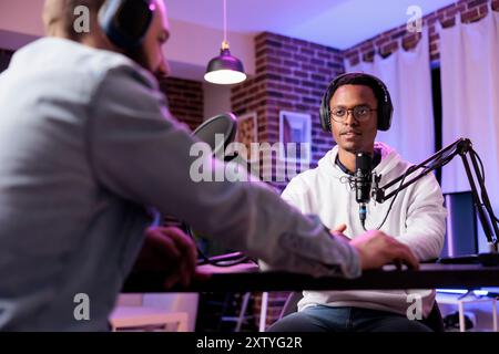 Podcast-Moderator hat Live-Gespräche mit man und streamt es für das Publikum in einer Internet-Entertainment-Show. Influencer, der sich mit Gästen unterhalten und im persönlichen Studio ausstrahlt Stockfoto