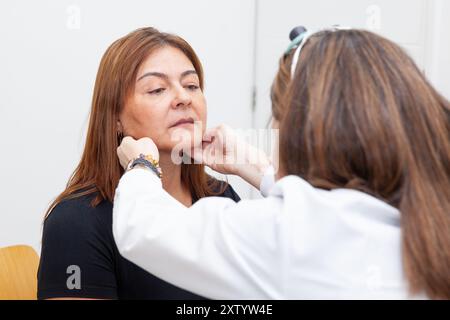 Dermatologe plant die Applikation von Botulinumtoxin bei einer mittleren Patientin. Ästhetische Medizin. Stockfoto