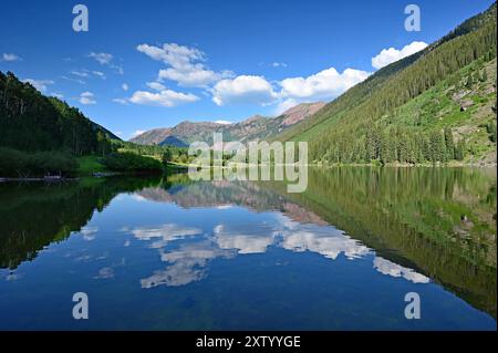 Kastanienbraune Glocken spiegeln sich am sonnigen Sommernachmittag unter dramatischer Sommerwolke im Maroon Lake. Stockfoto