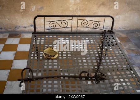 Bett und Fesseln in einer Gefängniszelle im kambodschanischen Sicherheitsgefängnis S-21. Stockfoto