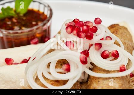 Traditioneller gegrillter Kebab mit Granatapfel, Zwiebeln und scharfer Sauce für ein köstliches kulinarisches Erlebnis Stockfoto