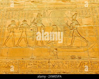 Wandrelief mit Darstellung von Pharoah Ptolemäus X. Alexander I. auf einem Segelboot mit Gehilfen im Tempel des Horus in Edfu, erbaut während der ptolemäischen Ära zwischen 237 und 57 v. Chr. in der Nähe von Assuan, Ägypten Stockfoto