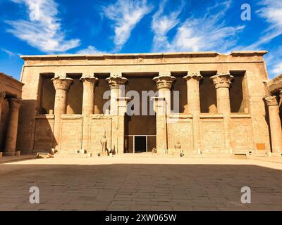 Innenhof mit zwei Granitstatuen von Horus, die den Eingang in den Tempel des Horus in Edfu bewachen, der während der ptolemäischen Ära zwischen 237 und 57 v. Chr. in der Nähe von Assuan, Ägypten erbaut wurde Stockfoto