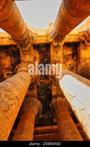 Blick auf die geschwärzte Decke des Tempels, gestützt von Blumensäulen in der Galerie des Hypostils im Tempel des Horus in Edfu, erbaut während der ptolemäischen Ära zwischen 237 und 57 v. Chr. in der Nähe von Assuan, Ägypten Stockfoto