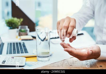 Geschäftsmann, Laptop und Medikamente mit Glas Wasser zur Verschreibung oder Tagesdosis im Büro. Nahaufnahme der Hände oder des Mitarbeiters mit Mineralflüssigkeit Stockfoto