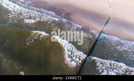 Aus der Vogelperspektive mit Sonnenaufgang über die ostsee mit Welle auf dem Sandstrand Stockfoto