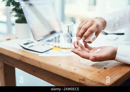 Geschäftsmann, Laptop und Pillen mit Wasser für ärztliche Verschreibung oder tägliche Dosierung im Büro. Nahaufnahme von Mitarbeiterhänden mit Mineralflüssigkeit für Stockfoto