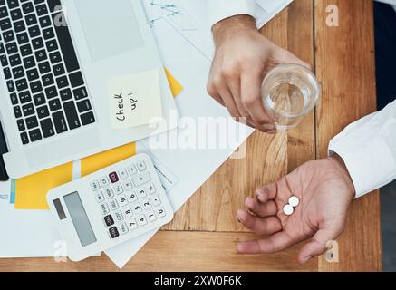 Geschäftsmann, Laptop und Pillen mit Wasser oben für Medikamente, Rezepte oder tägliche Dosierung im Büro. Draufsicht des Mitarbeiters mit Mineralflüssigkeit und Stockfoto
