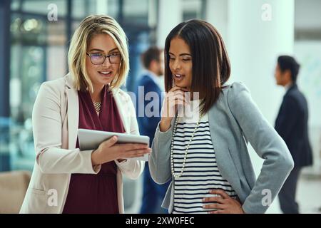 Beratung, Diskussion und Frauen im Büro mit Tablet, Meinung oder Team mit Projektmanagementvorschlag. Online-Bericht, Planung und Mentor mit Mitarbeiter Stockfoto