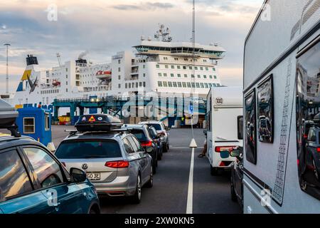 Trelleborg, Schweden - 9. August 2024: Touristen mit Autos und Wohnwagen warten in der Warteschlange am Kai, während Pkw von der TT-Line Fähre 'A aussteigen Stockfoto