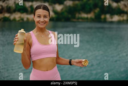 Eine fitte, junge Frau, die einen gesunden und aktiven Lebensstil am Waters Edge freudig annimmt Stockfoto