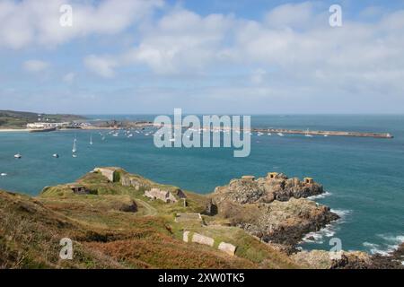 Sehen Sie die Szene des Hafens und des Strandes Alderney Channel Islands mit den Festungen der deutschen Nazis aus dem 2. Weltkrieg Atlantikmauer auf Hügeln Stockfoto