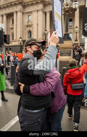 Melbourne, Australien. August 2024. Gegenprotestierende umarmen sich während einer Anti-Trans- und Gegendemonstration. Die Schritte des Victorian State Parliament waren Zeuge einer Kollision von Ideologien, da Anti-Trans-Demonstranten eine Plattform fordern, während linke Aktivisten sie mit Lärm und Musik übertränken wollen. Die Polizeipräsenz verstärkte das Gefühl und es gab Kurse, da die Polizei die Gruppen getrennt hielt. Die berittene Polizei wurde benutzt, um die Pro-Trans-Demonstranten zurückzudrängen. Quelle: SOPA Images Limited/Alamy Live News Stockfoto