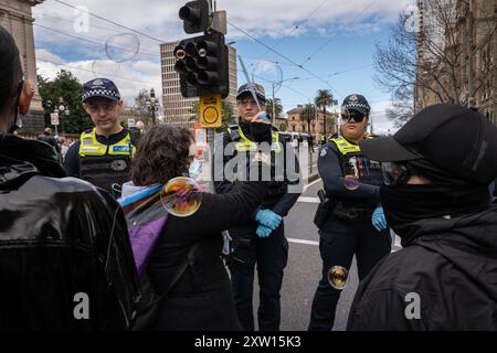 Melbourne, Australien. August 2024. Ein Demonstrant erzeugt Blasen vor der Polizei, um sie während der Demonstration zu ärgern. Trans-Rechts-Aktivisten stoßen mit der Polizei zusammen, als sie eine Anti-Trans-Gruppe im Parlamentsgebäude in melbourne bekämpfen, Festnahmen durchgeführt wurden, alberne Schnur und Wasserblasen wurden von den Gegenprotestierenden auf Polizeibeamte verwendet. Quelle: SOPA Images Limited/Alamy Live News Stockfoto