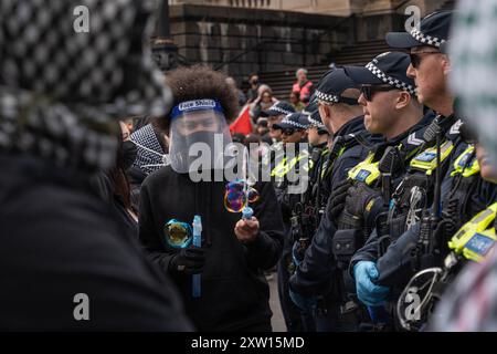 Melbourne, Australien. August 2024. Ein Demonstrant läuft neben einer Polizeilinie und erzeugt während der Demonstration Wasserblasen. Trans-Rechts-Aktivisten stoßen mit der Polizei zusammen, als sie eine Anti-Trans-Gruppe im Parlamentsgebäude in melbourne bekämpfen, Festnahmen durchgeführt wurden, alberne Schnur und Wasserblasen wurden von den Gegenprotestierenden auf Polizeibeamte verwendet. Quelle: SOPA Images Limited/Alamy Live News Stockfoto