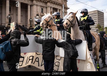 Melbourne, Australien. August 2024. Berittene Polizeibeamte setzen Gewalt ein, um während der Demonstration vor ihnen stehende Demonstranten mit Schildern zu bewegen. Trans-Rechts-Aktivisten stoßen mit der Polizei zusammen, als sie eine Anti-Trans-Gruppe im Parlamentsgebäude in melbourne bekämpfen, Festnahmen durchgeführt wurden, alberne Schnur und Wasserblasen wurden von den Gegenprotestierenden auf Polizeibeamte verwendet. Quelle: SOPA Images Limited/Alamy Live News Stockfoto