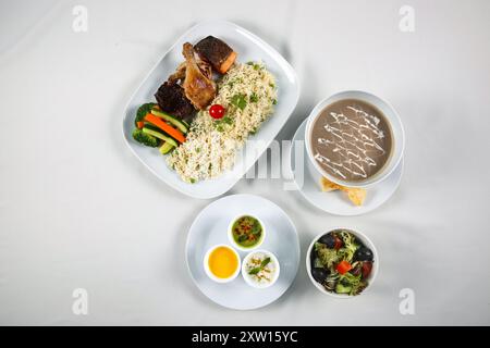 Gebratener Reis mit Knoblauch und grüner Erbse mit gegrilltem Gemüse, Grillhähnchen, Grilllachs, Pilzsuppe, indischer Rita, Salatschüssel Stockfoto